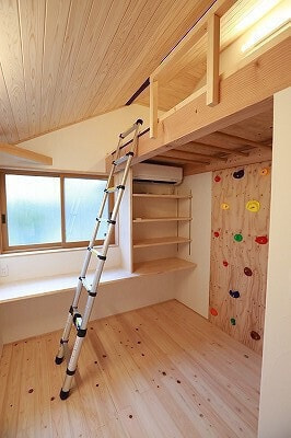 子供部屋入り口から撮影。窓際に作り付けデスク、右手に棚。ロフトとボルダリングで遊びと学びの空間を両立。