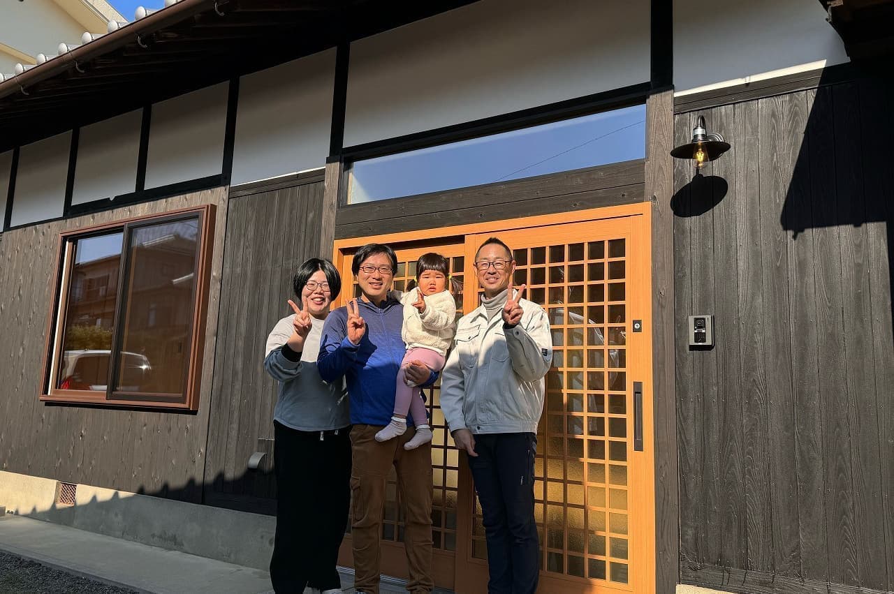 四国中央で手がけた築50年のリノベーション事例。リノベーション後の玄関前でA様ご家族と記念撮影。