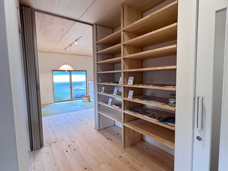 ホールに設置された造作の可動棚。棚板の高さを自由に変えられるため、様々なものを効率よく収納できる。