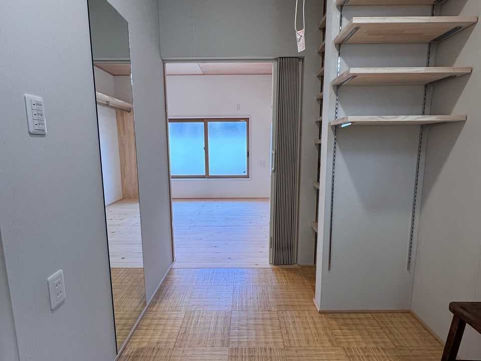 リノベーション後の脱衣所。壁面に設置された可動棚と鏡で、収納から身支度までスムーズに行える機能的な空間。