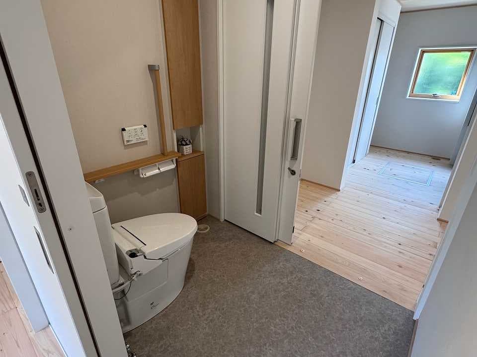 リノベーション後のトイレ。入口が２箇所あり、どちら乗ろうかからでもアクセスしやすい設計。扉は引違戸。車椅子でも利用できるよう広々としたバリアフリー仕様。