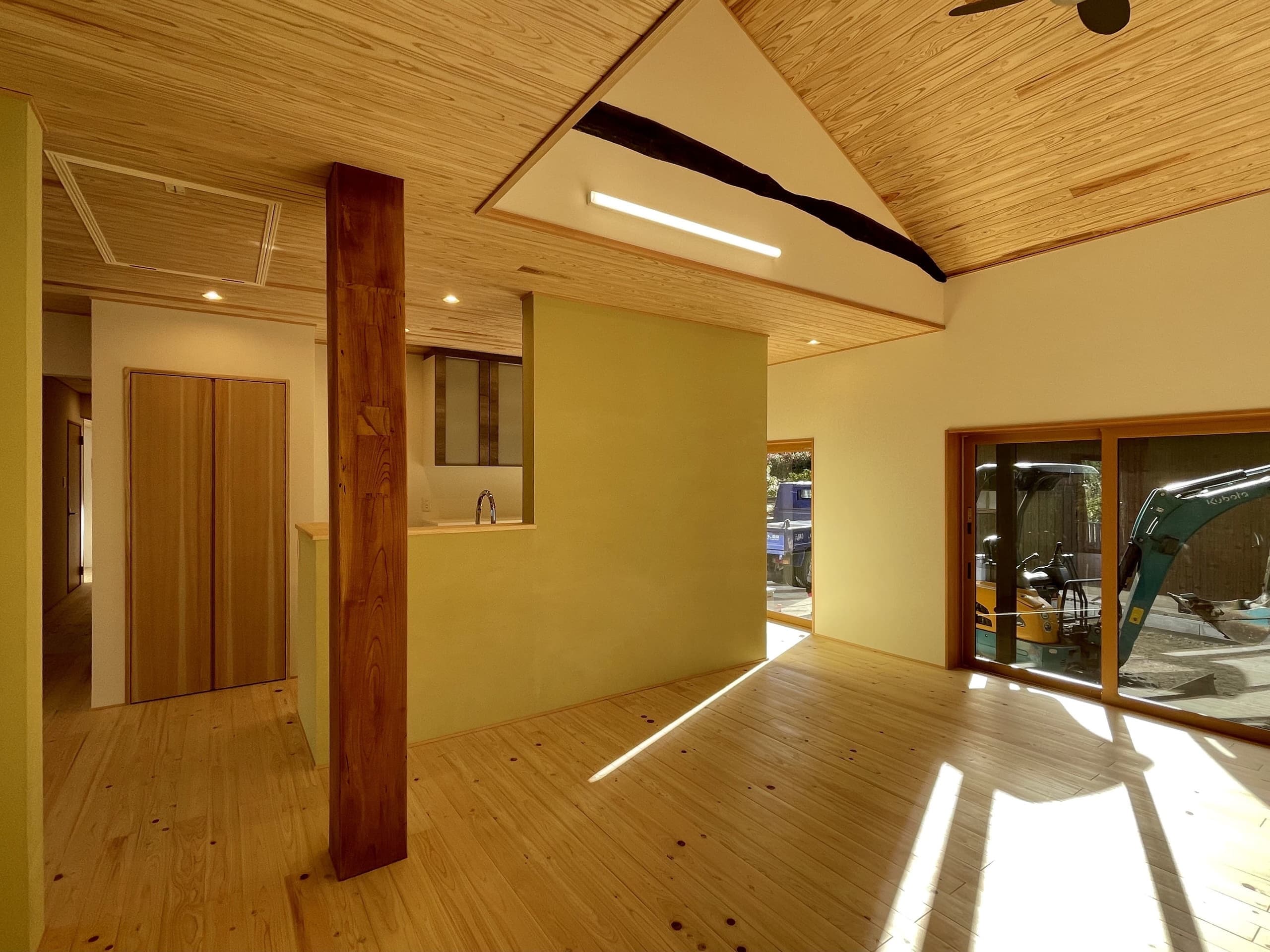 見せ梁と木の床が調和する、別角度からのリビングの様子