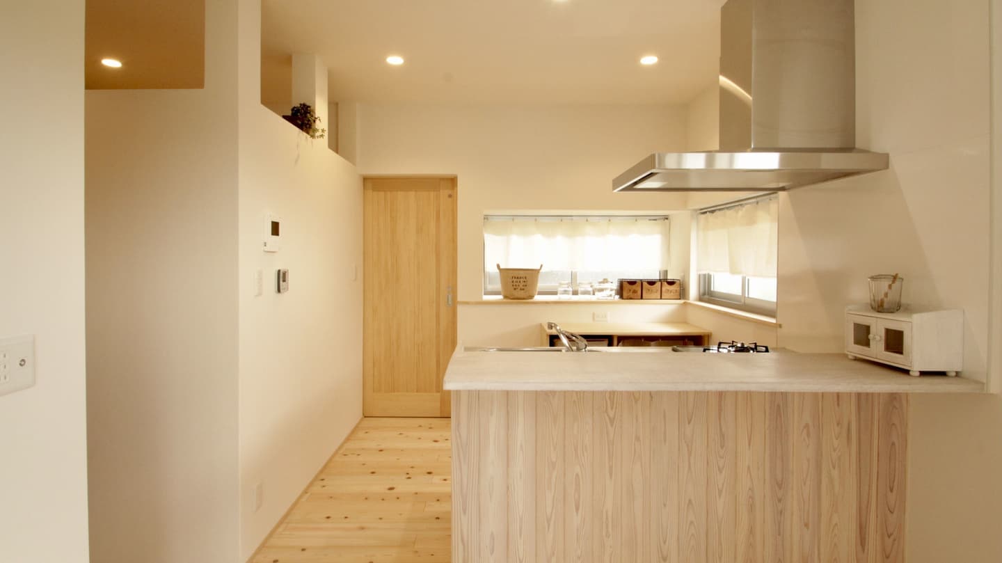 シンプルな白壁に木の質感が映える、ナチュラルなカフェ風キッチン